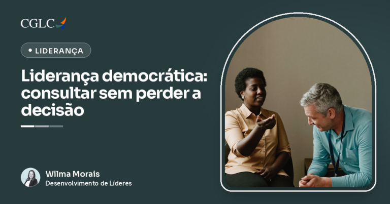 Mulher negra de camisa cor de areia falando com a palma da mão aberta voltada para cima, e homem grisalho de camisa azul-clara sentado ao lado, inclinado para a frente com as mãos unidas, ouvindo.