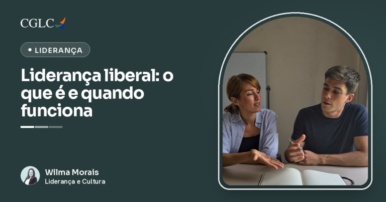 Mulher de camisa listrada azul-clara e homem de camiseta escura sentados lado a lado à mesa, na mesma altura; ela fala com a mão aberta apoiada na mesa e ele escuta segurando uma caneta, com um caderno aberto em branco à frente dos dois