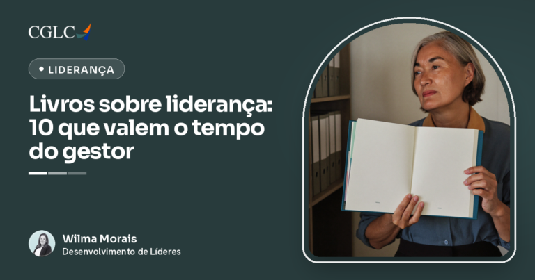 Executiva em pé diante de uma estante de arquivos, segurando um livro aberto e olhando para o lado com expressão reflexiva